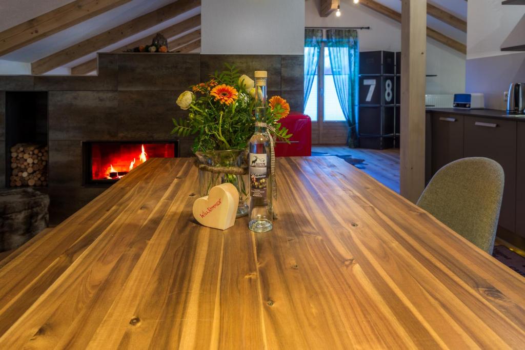 a wooden table with a vase of flowers on top of it at Alpen Appartement BelEtage in Mayrhofen