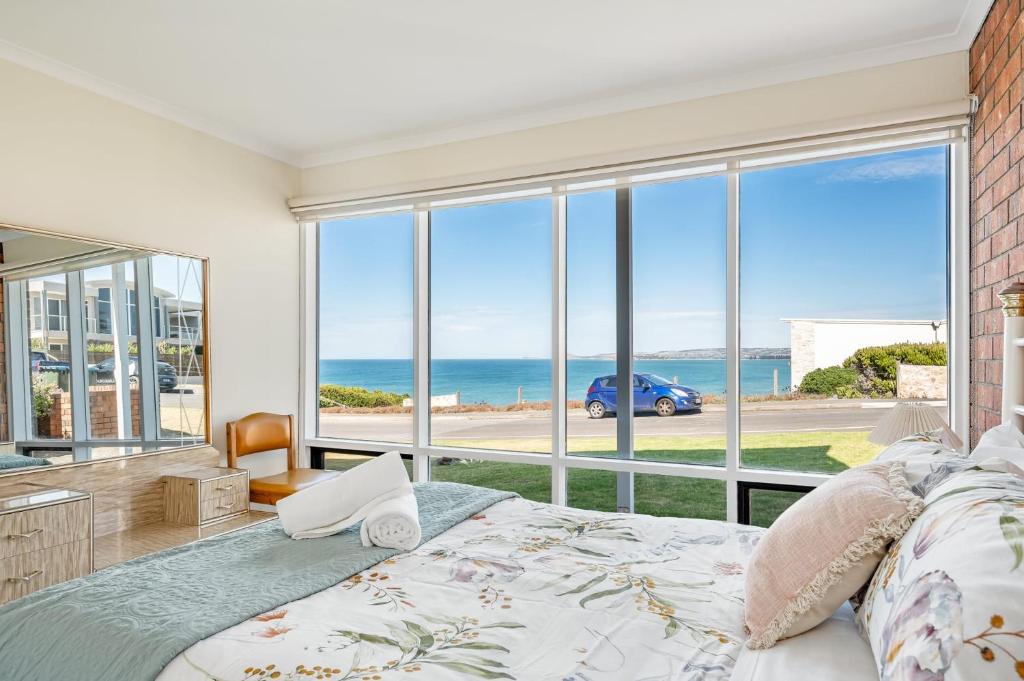 a bedroom with a bed and a view of the ocean at Beachfront Views at Southern Sands 1 in Port Elliot