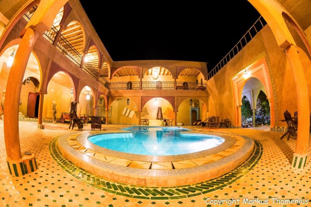 una gran piscina cubierta en un edificio con una habitación grande en Maison Merzouga Guest House en Merzouga