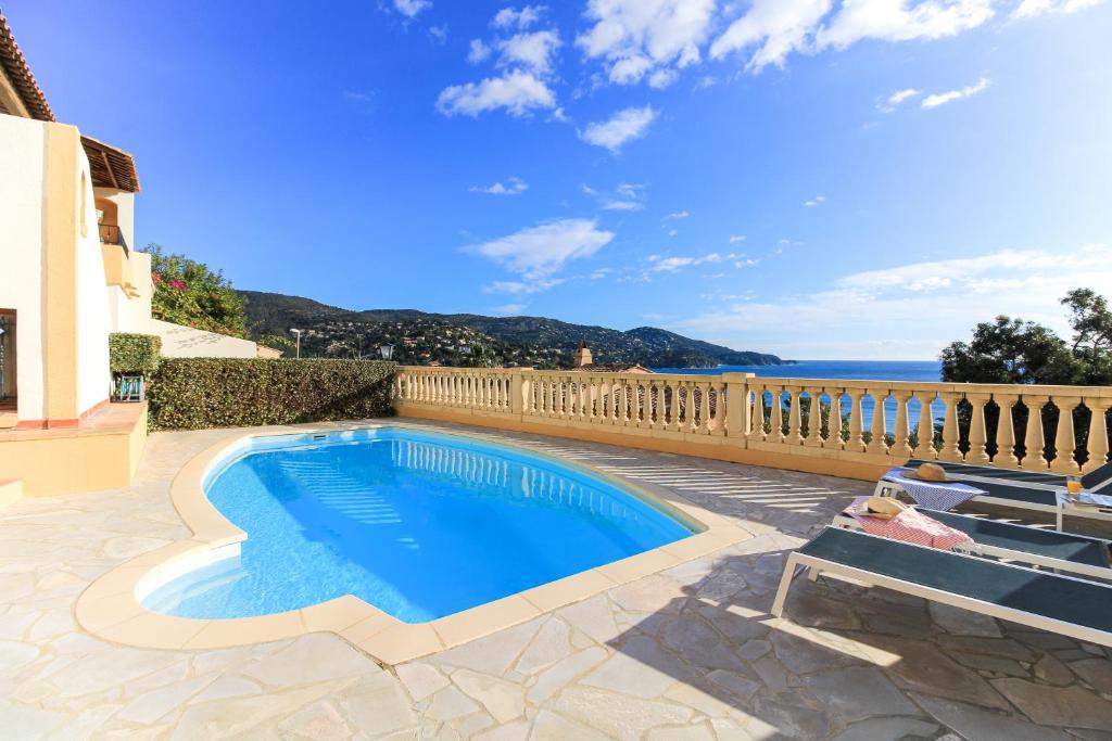 a swimming pool in a patio with a view of the ocean at SELECT'SO HOME - Villa PANORAMA - Services hôteliers & prestations de qualité in Le Lavandou