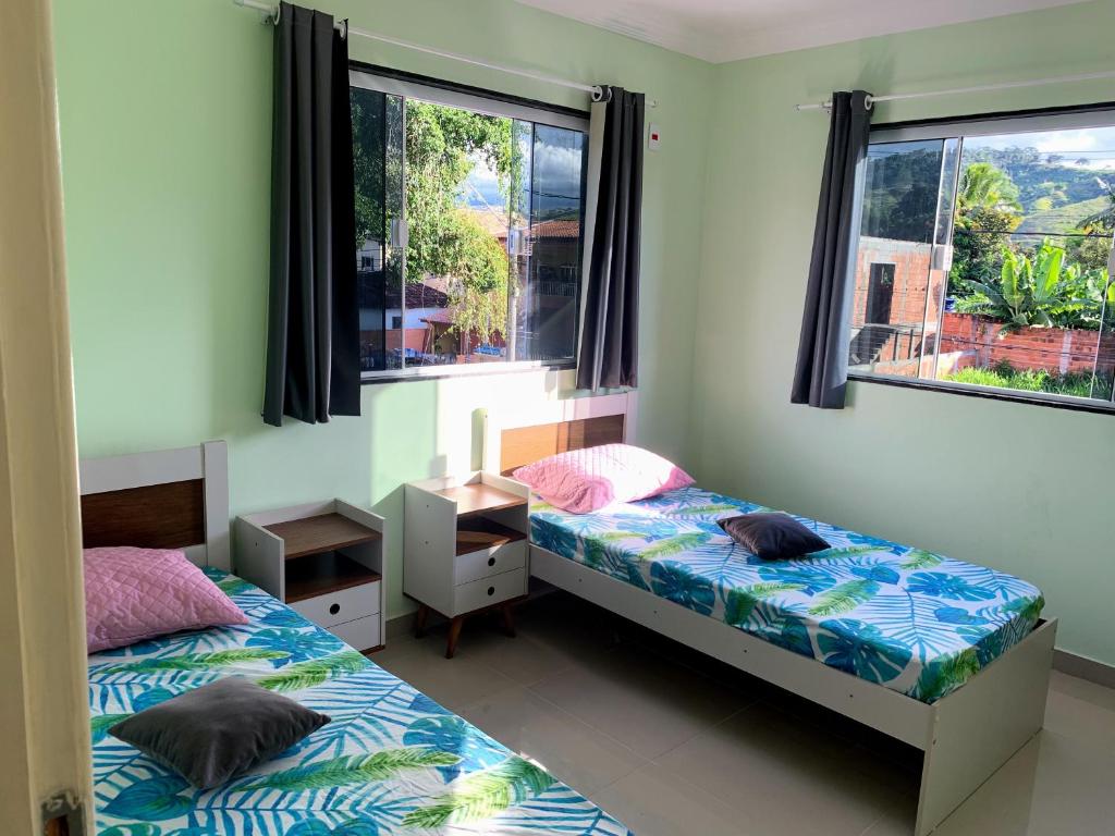 2 Betten in einem Zimmer mit 2 Fenstern in der Unterkunft Casa e área Gourmet. Cardoso Moreira-RJ in Cardoso Moreira