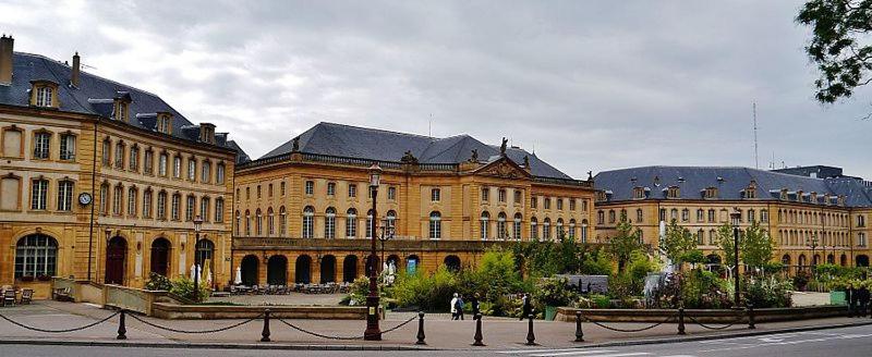 a large yellow building with a street in front of it at LES MIRABELLES in Metz