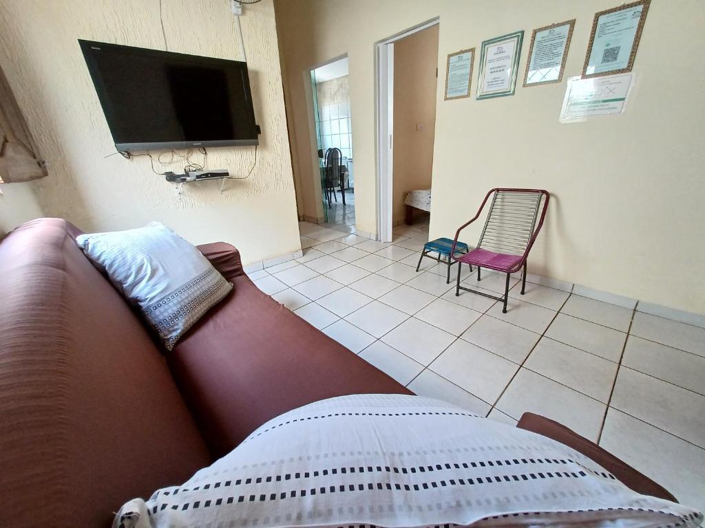 a living room with a couch and a tv at CASA DE TEMPORADA NOSSO CANTINHO A in Carolina