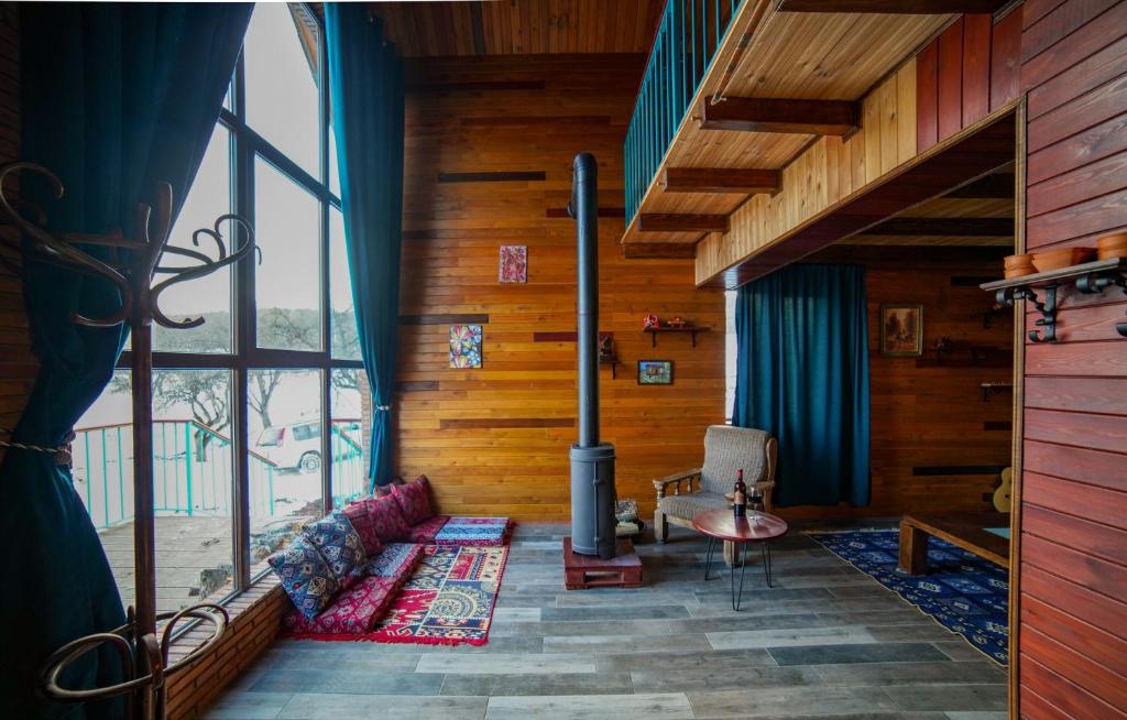 a living room with a fireplace and a large window at Sakudela in Nikortsminda