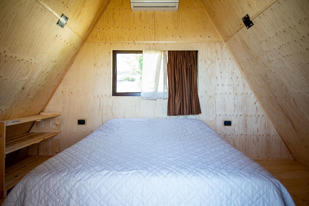a large bed in a wooden room with a window at La Luna sul Trebbio in Modigliana