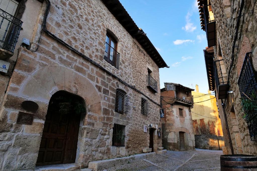 un callejón en un antiguo edificio de piedra con una puerta en Hospederia Jaramillo, en Peñaranda de Duero