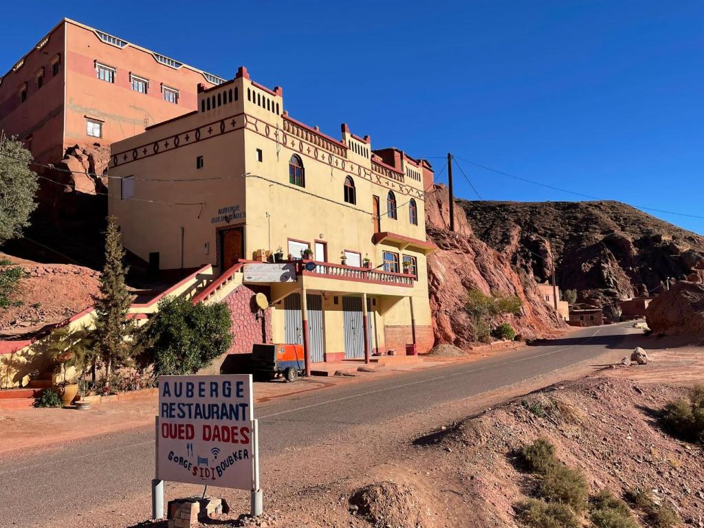 a building on the side of a road with a sign at Auberge oued dades in Boumalne