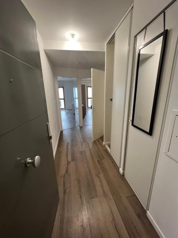 a hallway of an apartment with a door and wooden floors at Appartement 2 pièces ligne 1 in Montreuil