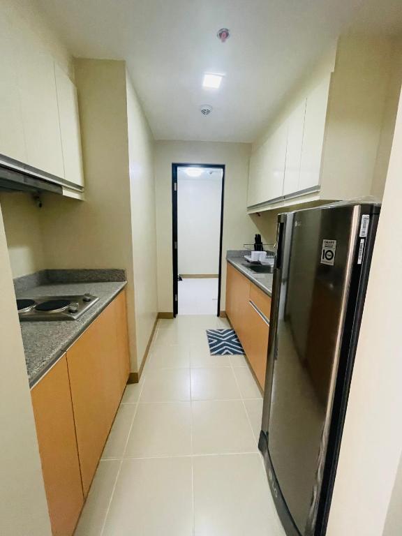 a kitchen with a stainless steel refrigerator in it at 1 Bedroom Condo unit @ Iloilo Business Center in Iloilo City