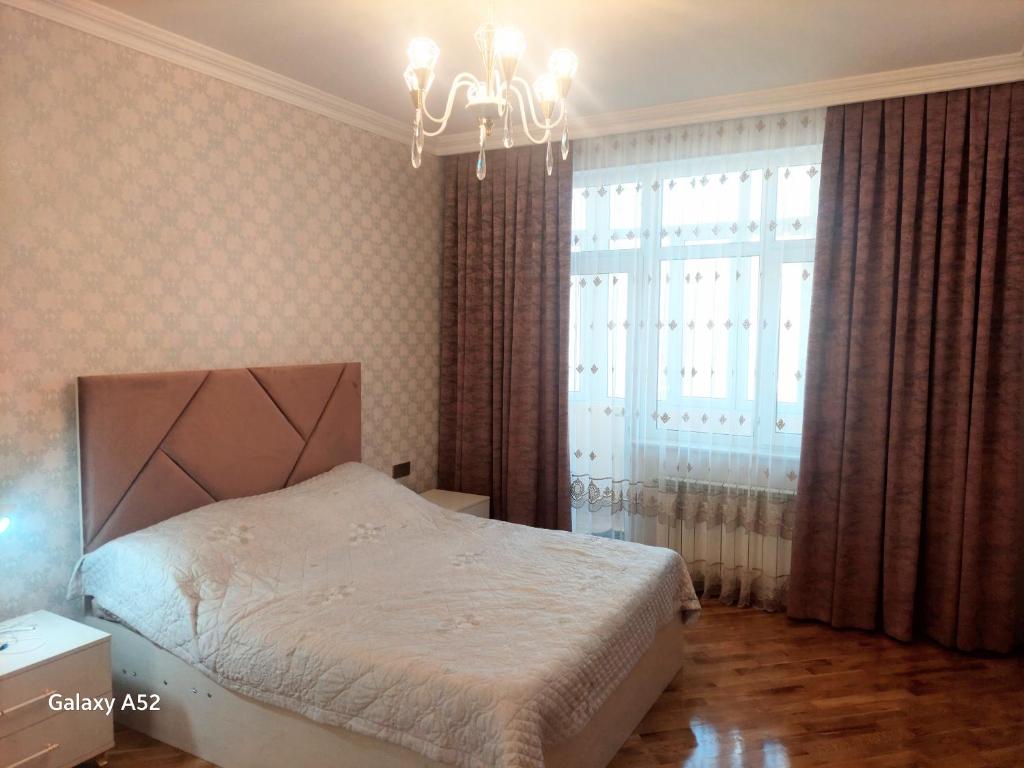 Luxury Guest House في سومقاييت: غرفة نوم بسرير وثريا ونافذة