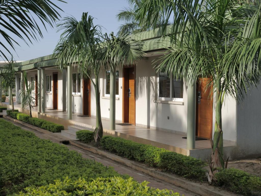 une maison avec des palmiers devant elle dans l'établissement Grand Hotel Juba, à Djouba