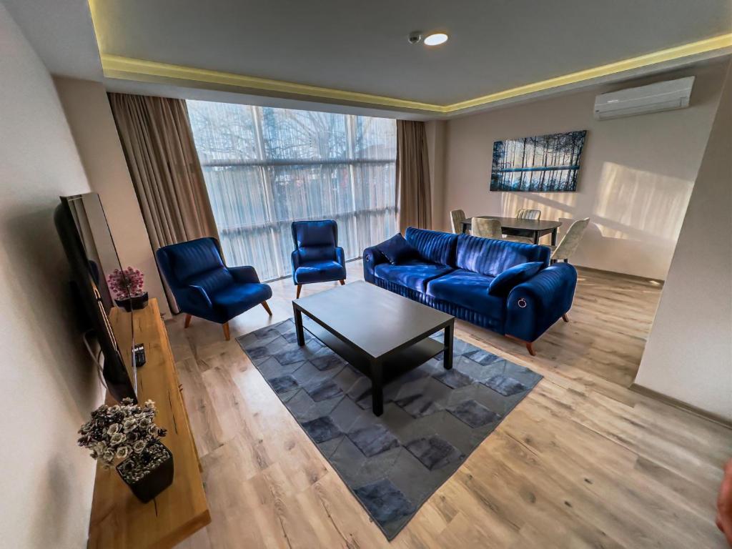 uma sala de estar com um sofá azul e cadeiras em MY SUITE em Yalova