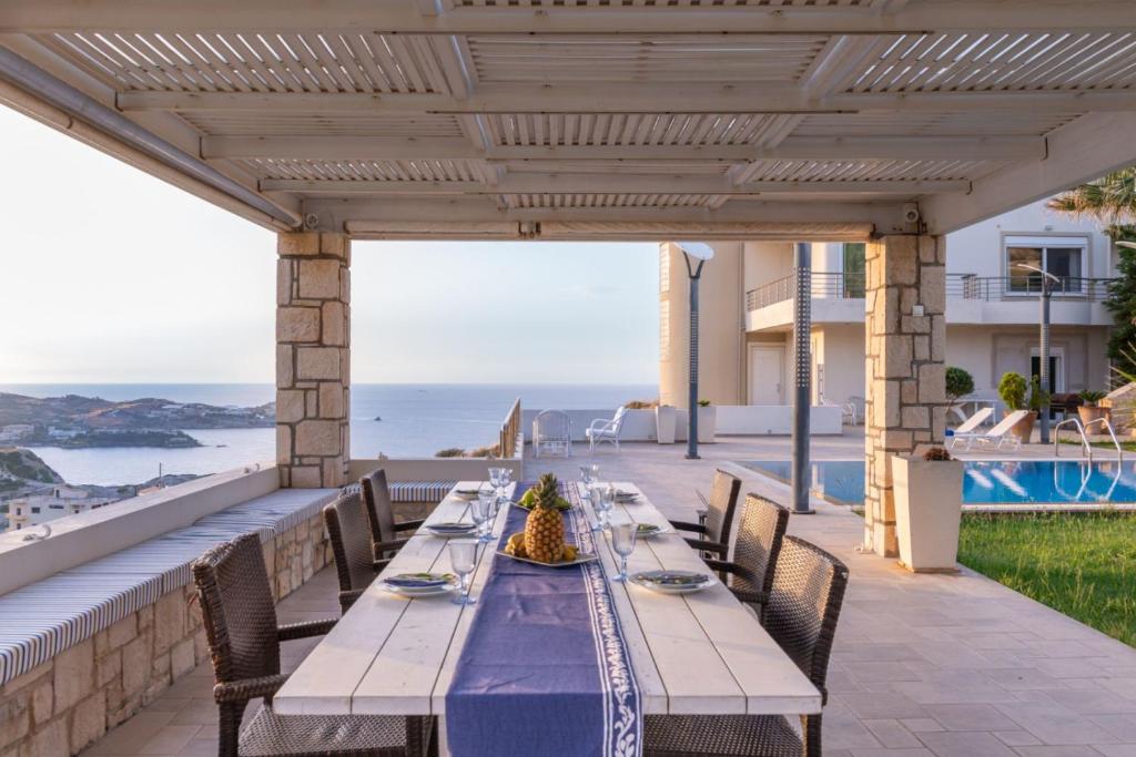 a table on a patio with a view of the ocean at Creta Vivere Villas in Agia Pelagia