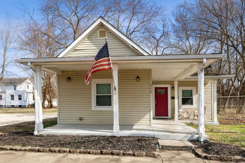 Una piccola casa con una bandiera americana sopra. di Chestnut St 3 Bedroom House in Historic Loveland a Loveland