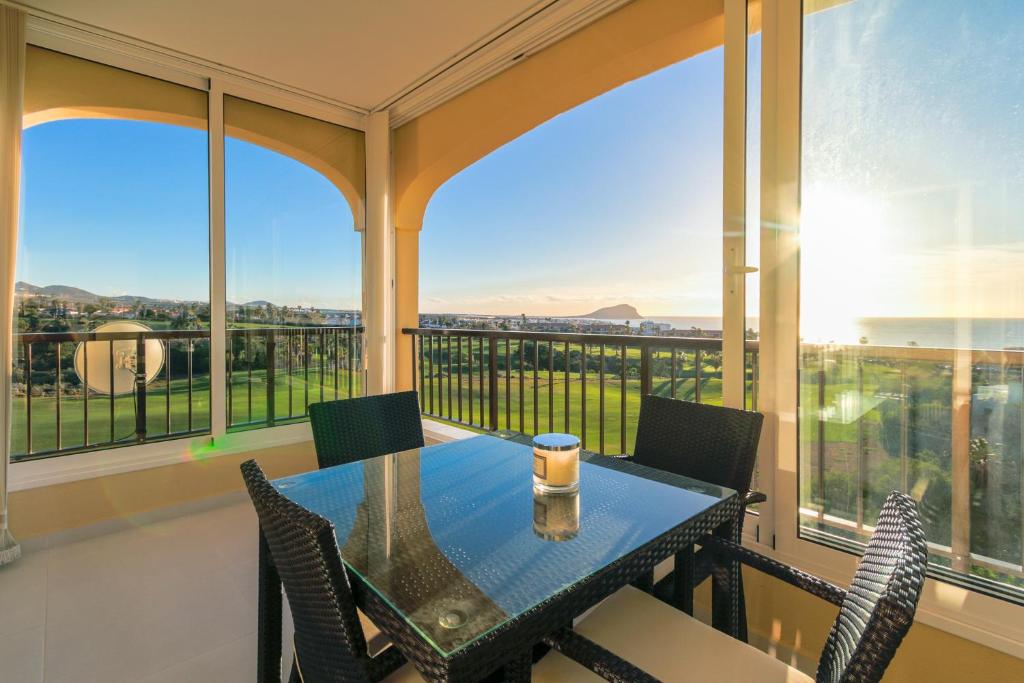 a dining room with a table and chairs on a balcony at Golf View Apartment - stunning ocean view Golf del Sur in San Miguel de Abona