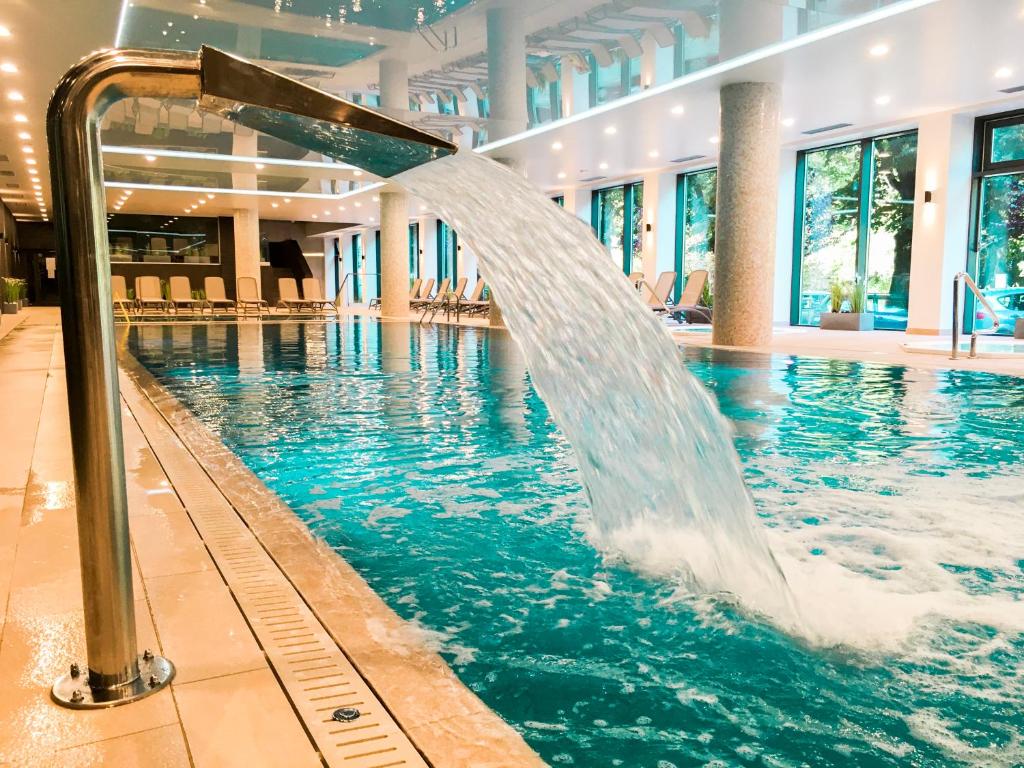 uma piscina com uma fonte de água num edifício em Nadmorskie Tarasy Apartament Park i Morze em Kolobrzeg