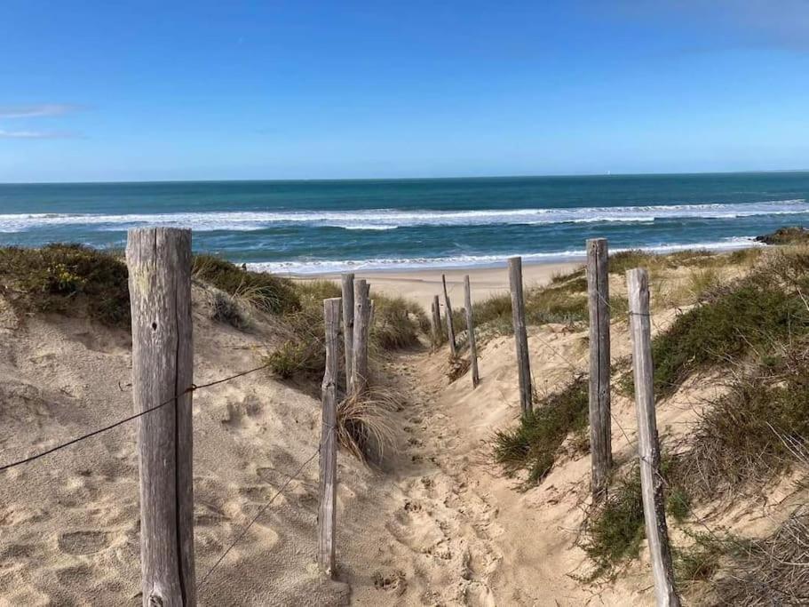 a wooden fence on a beach near the ocean at Maison de bourg à 5 minutes de Soulac Sur Mer in Talais