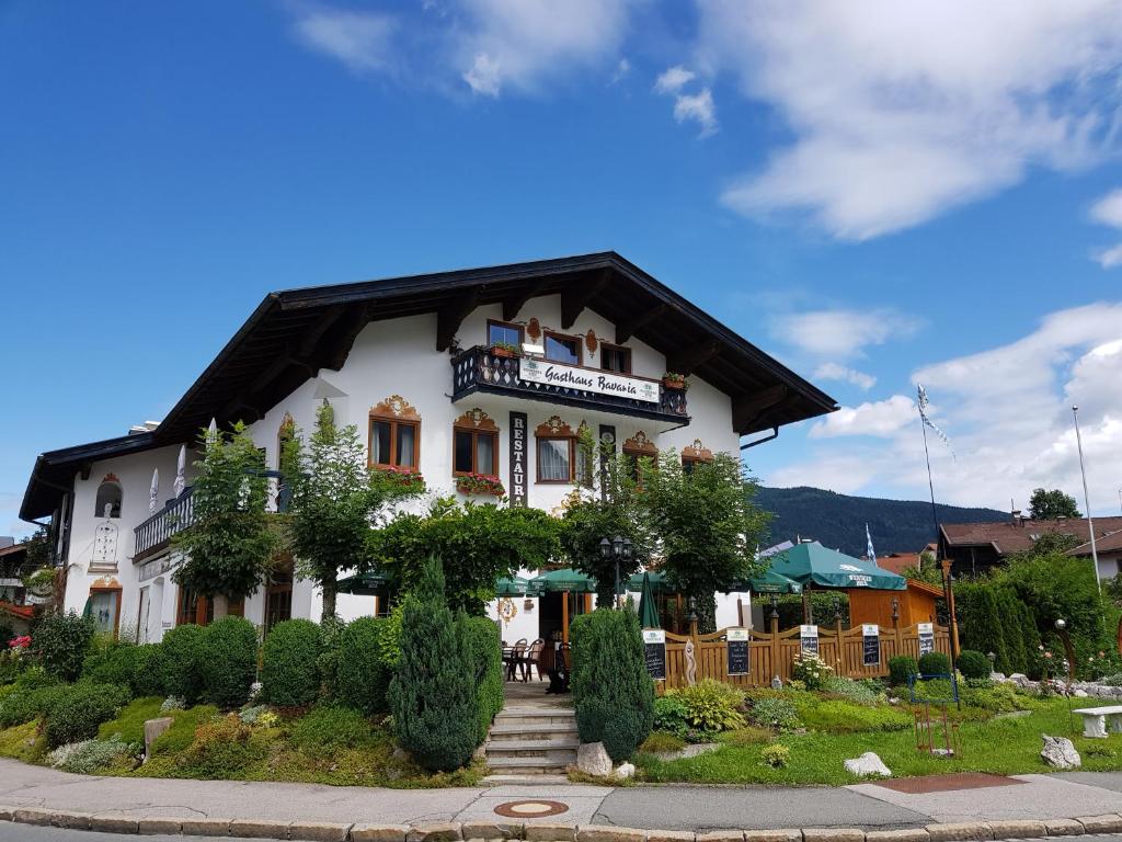 ein weißes Gebäude mit Balkon darüber in der Unterkunft Hotel Bavaria in Inzell