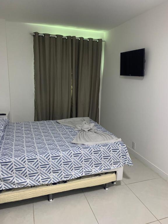 1 dormitorio con 1 cama con edredón azul y blanco en Golden Lake - Vista Lagoa, en Arraial do Cabo