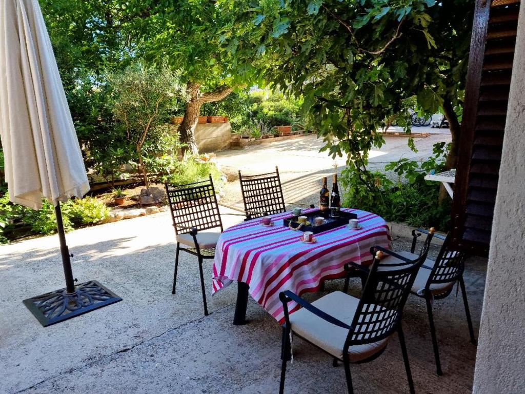 a table with chairs and an umbrella on a patio at Villa Agava in Vrboska