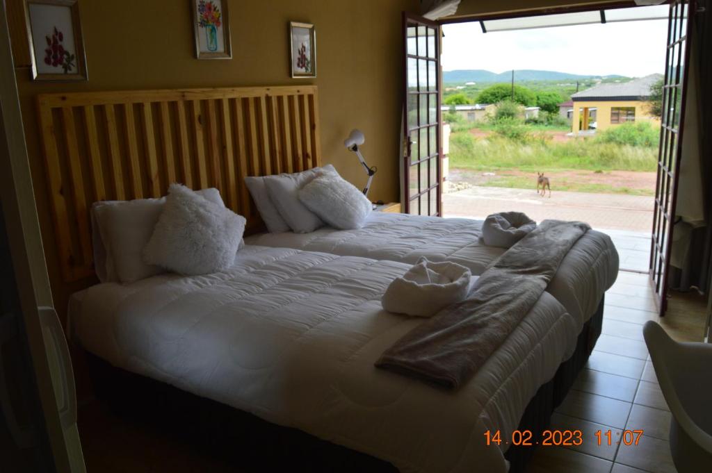 1 dormitorio con 1 cama grande y toallas. en Glorious Home Bed & Breakfast en Mochudi