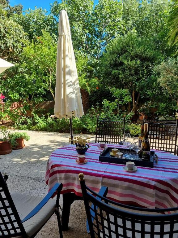 a table with a white umbrella and a table with chairs at Villa Agava in Vrboska