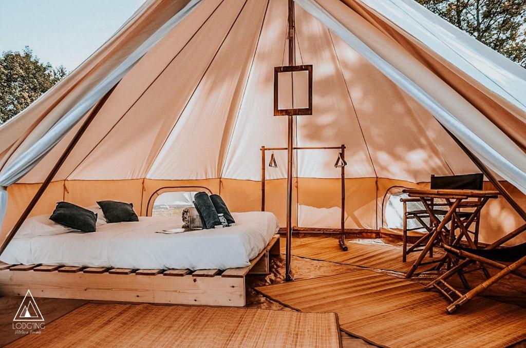 a tent with a bed and a desk in it at Lodg'ing Nature Camp Luberon in Saint-Michel-lʼObservatoire