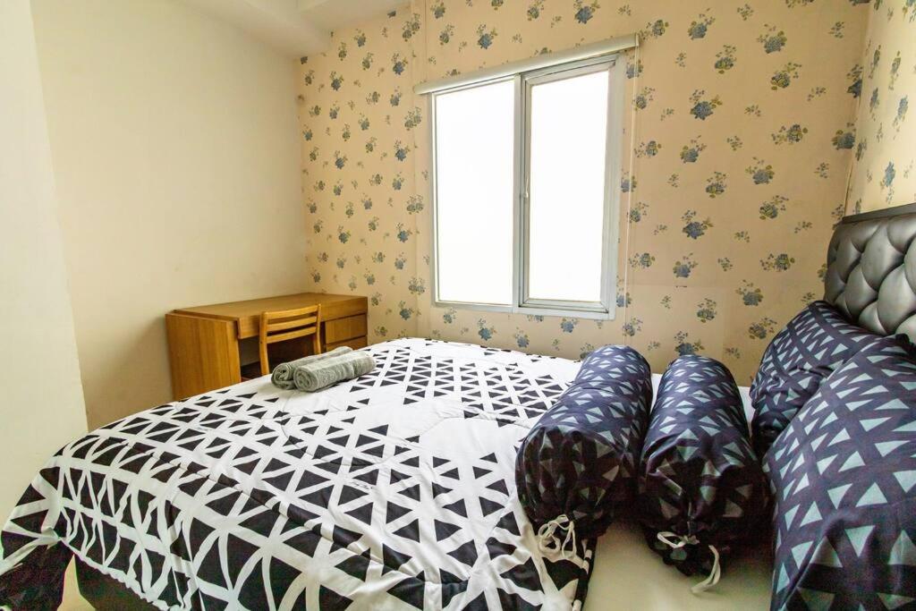 um quarto com uma cama e uma janela em Cozy 2 Bedroom Apartemen Pavilion Permata em Dukuhpakis