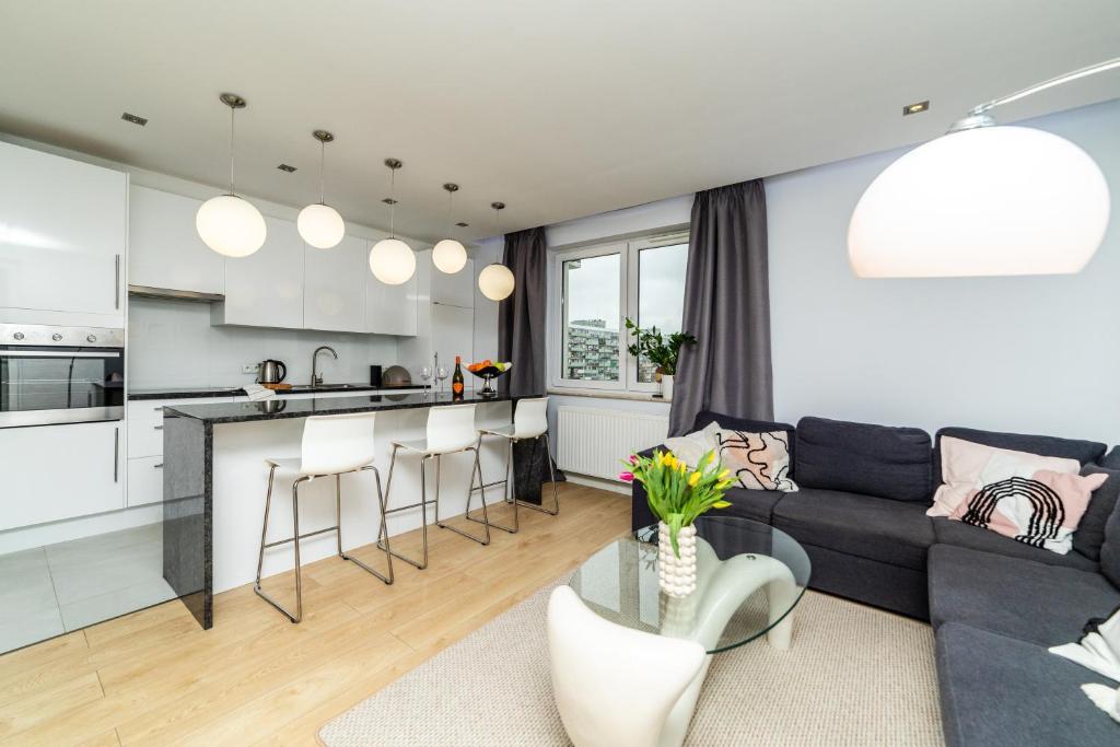 a living room with a couch and a kitchen at Apartament Modern w Albatross Towers Gdańsk in Gdańsk