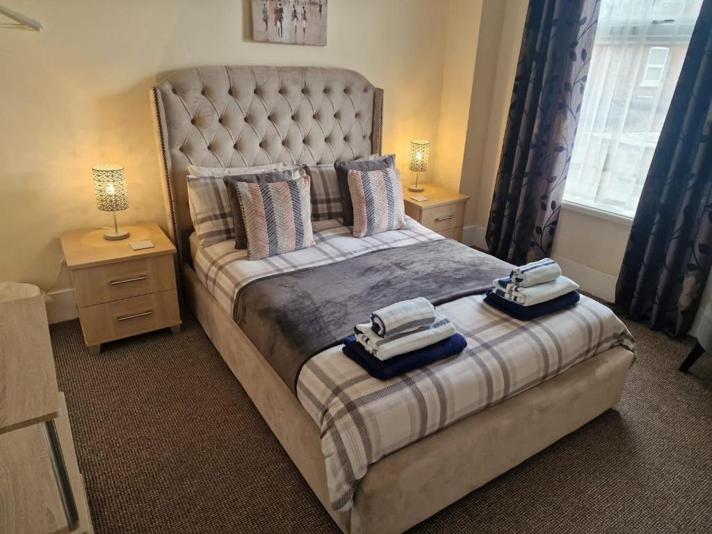 a bedroom with a large bed with two towels on it at hewitt place in Crewe