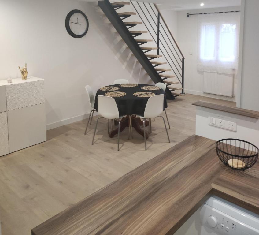 uma sala de jantar com uma mesa e uma escada em Une Parenthèse Enchantée em Saint-Sébastien-sur-Loire