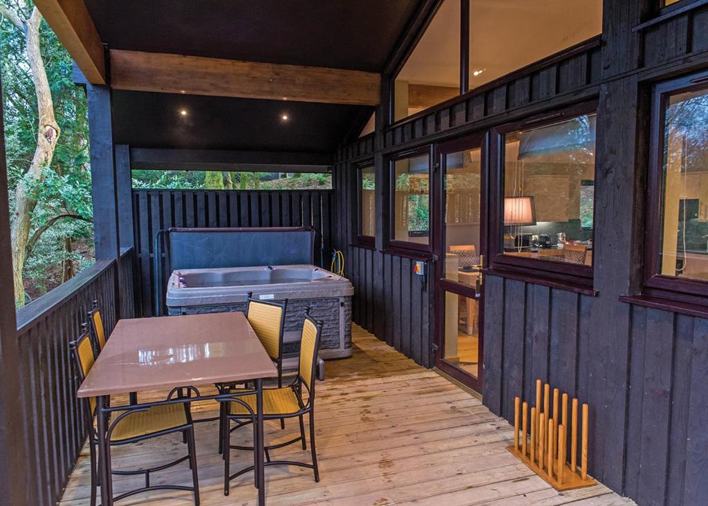 a screened in porch with a table and a bed at Brockwood Hall Lodges in Silecroft