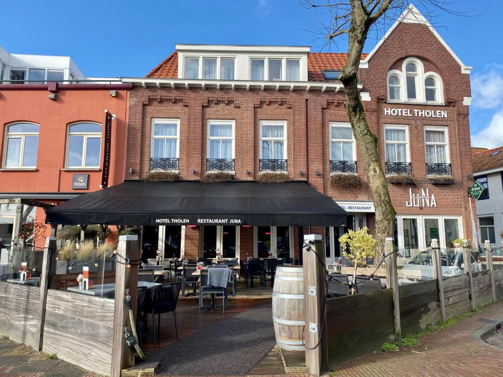 un restaurante con toldo negro frente a un edificio en Hotel Tholen en Tholen