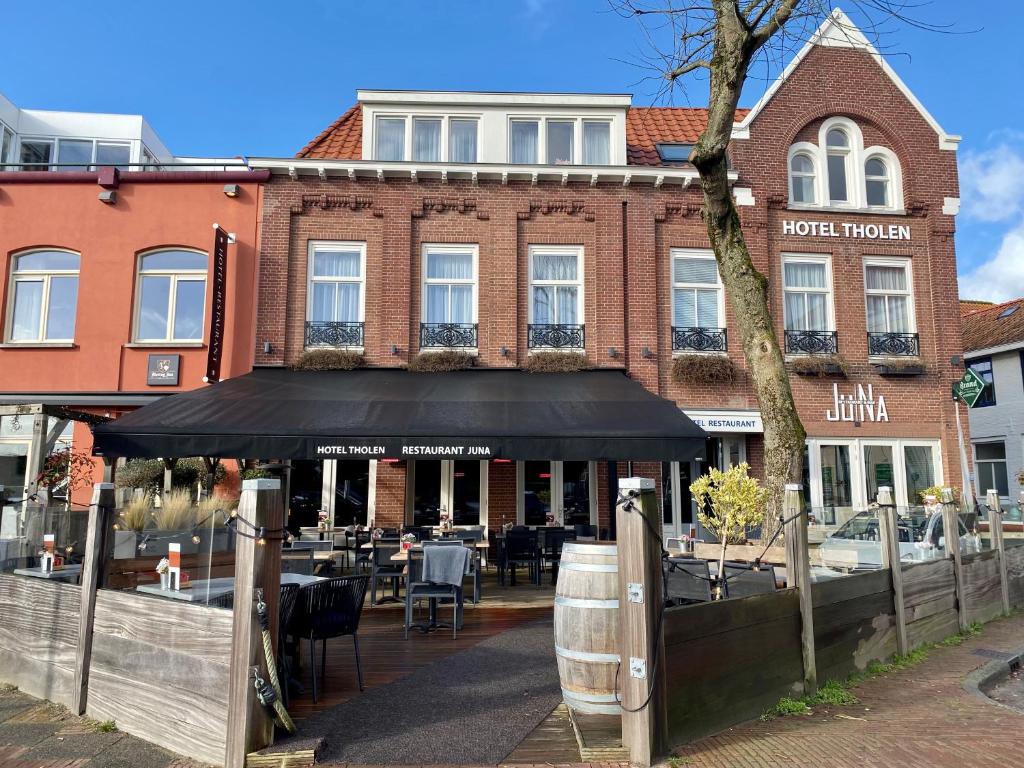 a restaurant with a black awning in front of a building at Hotel Tholen in Tholen