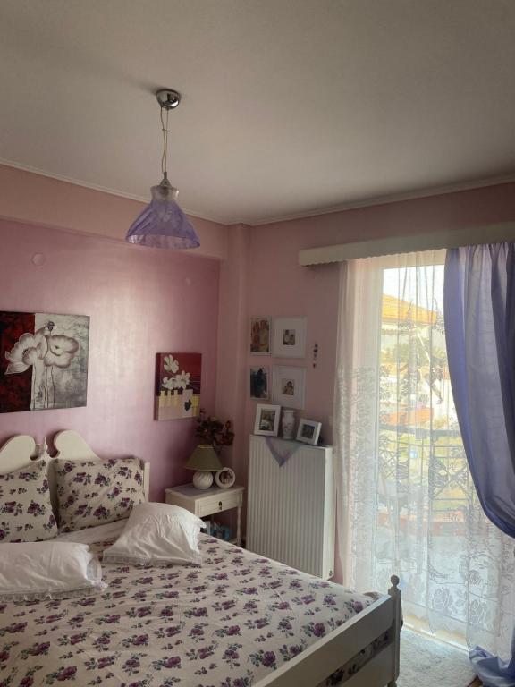 a bedroom with a bed and a large window at Πηνελόπη Apartment 3-bed flat in Tripolis