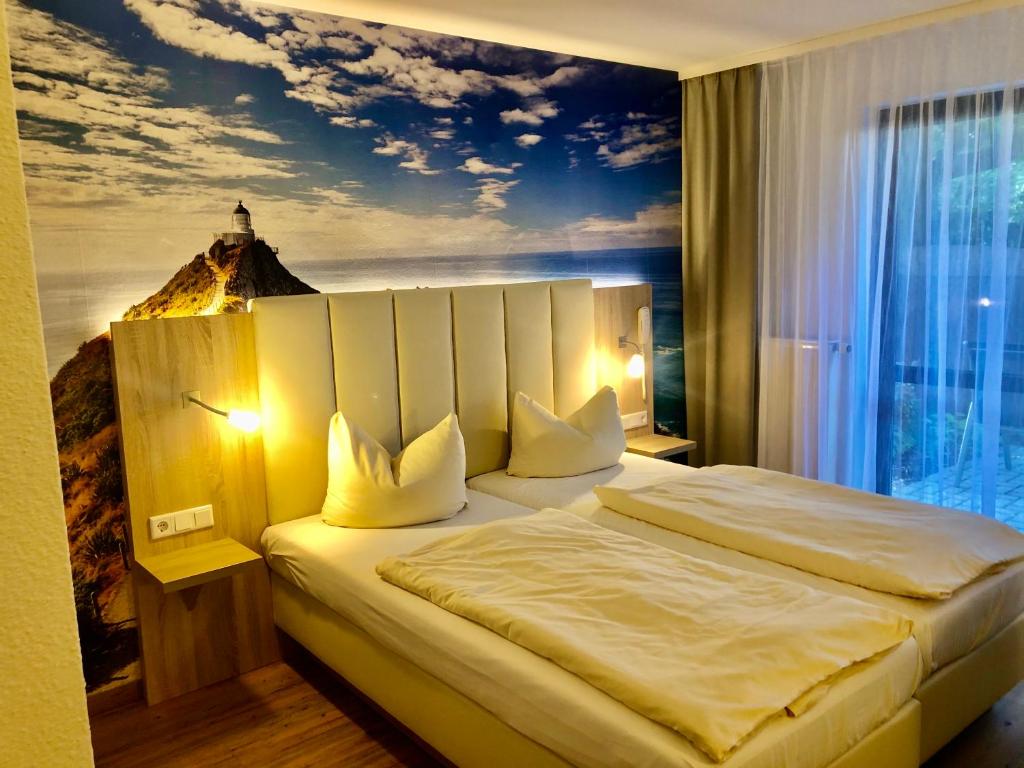 a bedroom with a large bed with a painting on the wall at Hotel zur Kanone in Tautenhain