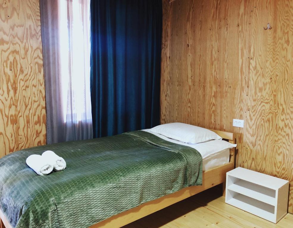 1 dormitorio con 1 cama con 2 toallas en A North Homestay, en Omalo