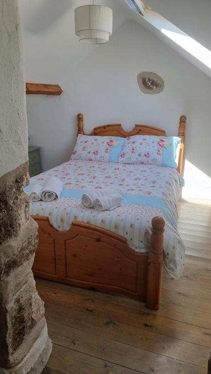 a bedroom with a wooden bed with pillows at Castell in Llangwyllog