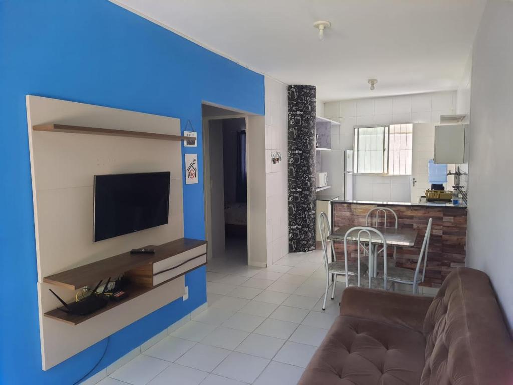 a living room with a couch and a tv and a kitchen at Casa proximo a praia in Paulista