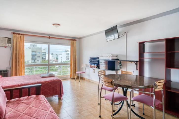 Habitación con cama, mesa y ventana en Apart Hotel Marilian en Salta