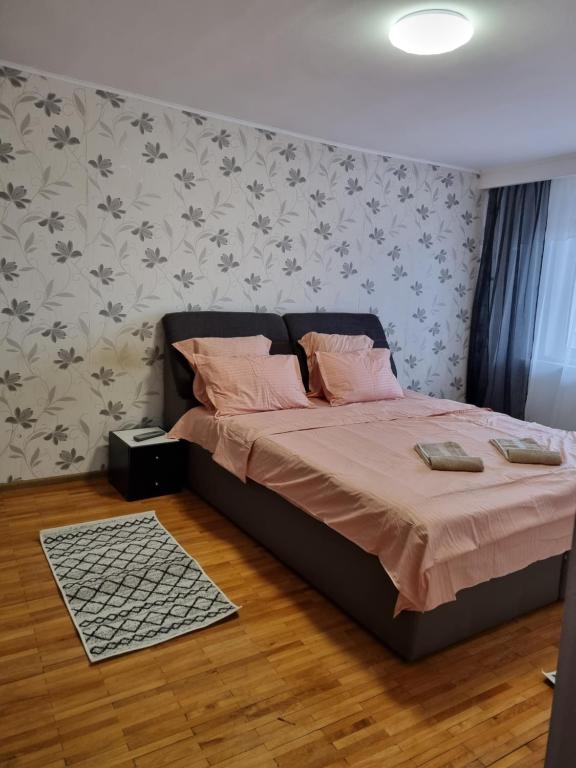 1 dormitorio con 1 cama con almohadas rosas en Marya's, en Râmnicu Vâlcea