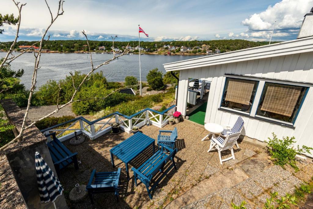 vistas a un patio con sillas y mesa en Fantastisk sjøhytte, 10 sengeplasser, strand og egen brygge, en Fredrikstad