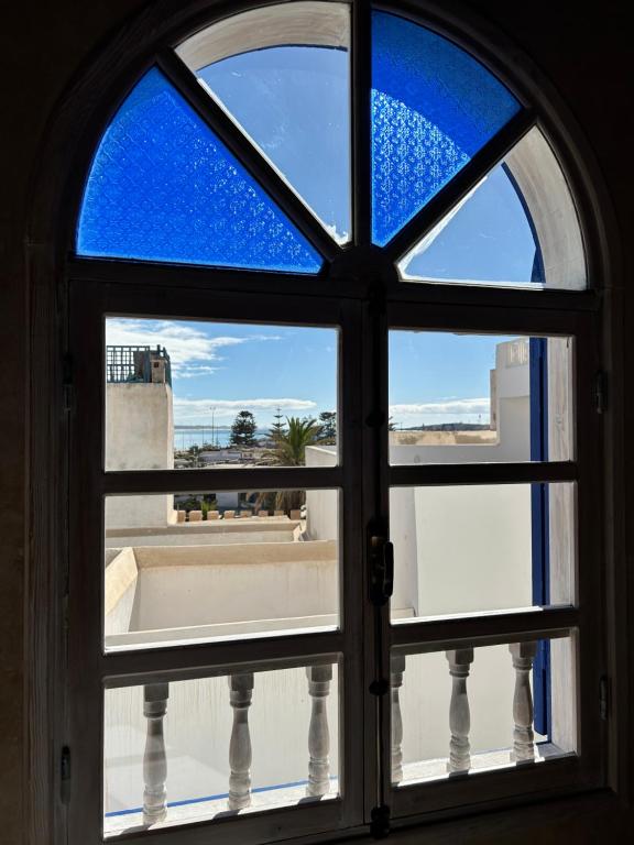 una ventana abierta con vistas a un balcón en Beau riad en médina, lumineux et avec terrasse privée sur mer en Esauira