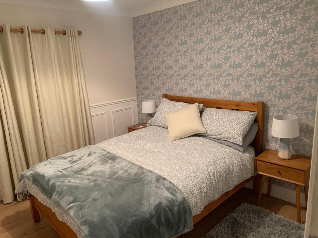 a bedroom with a bed and two lamps on tables at Toms Cottage in Longford