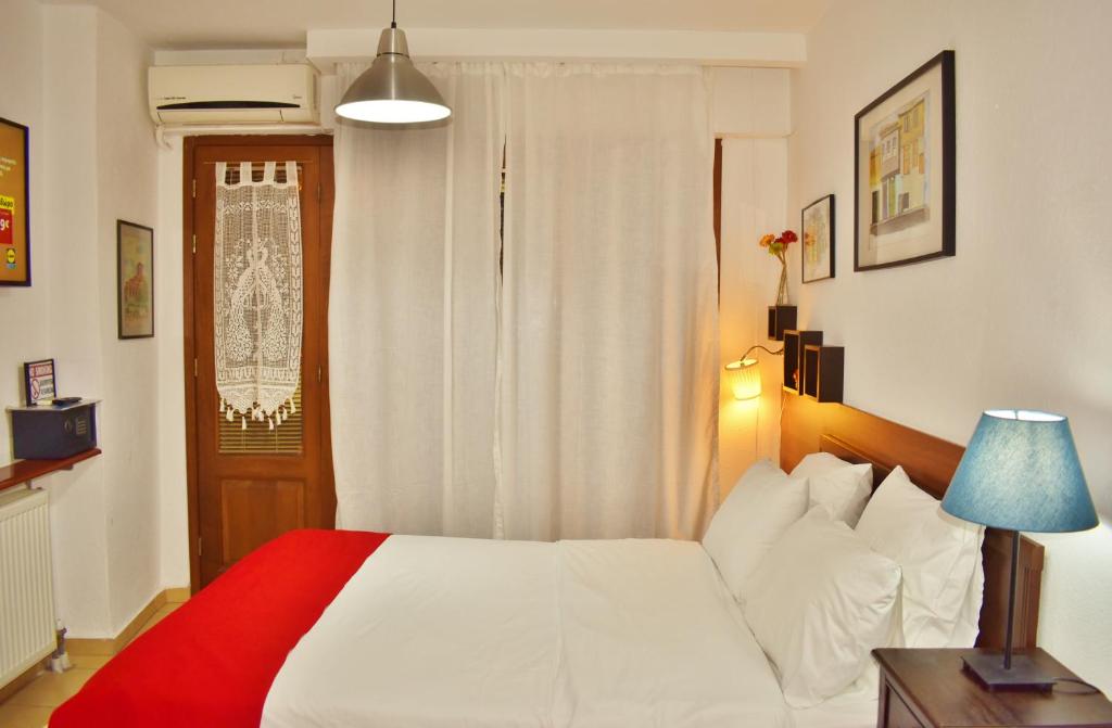 um quarto com uma cama branca e uma janela em Kripis Studio Thessaloniki em Tessalônica