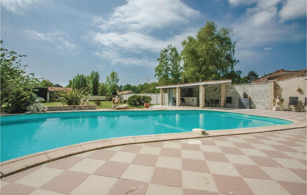 a swimming pool in a yard with a house at Stunning Home In Saint-vivien-de-medoc With 4 Bedrooms And Outdoor Swimming Pool in Saint-Vivien-de-Médoc