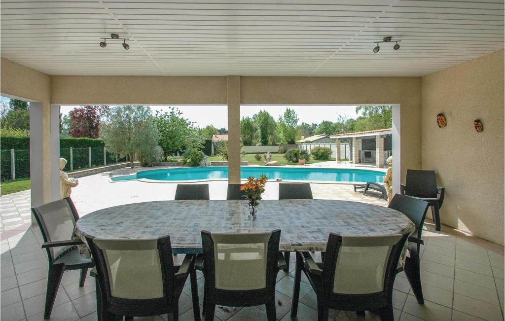 a dining room with a table and chairs and a pool at Stunning Home In Saint-vivien-de-medoc With 4 Bedrooms And Outdoor Swimming Pool in Saint-Vivien-de-Médoc