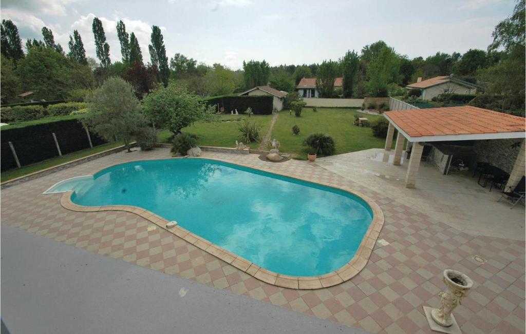 a large swimming pool in a yard with a house at Stunning Home In Saint-vivien-de-medoc With 4 Bedrooms And Outdoor Swimming Pool in Saint-Vivien-de-Médoc