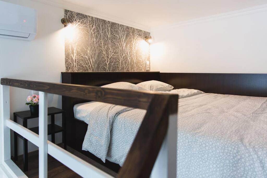 sypialnia z łóżkiem z czarno-białą ramą w obiekcie Central Private Lofts w Budapeszcie