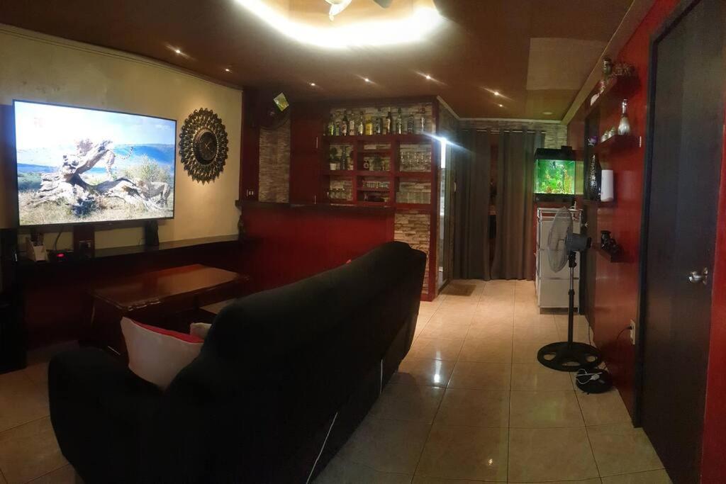 Billgren House في Imus: غرفة معيشة مع أريكة وتلفزيون بشاشة مسطحة